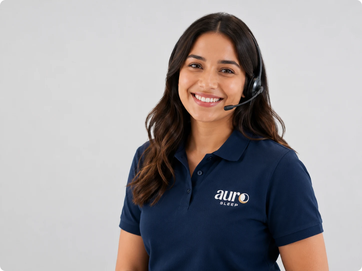 Smiling Auro Sleep customer support adviser wearing a navy branded polo shirt and headset